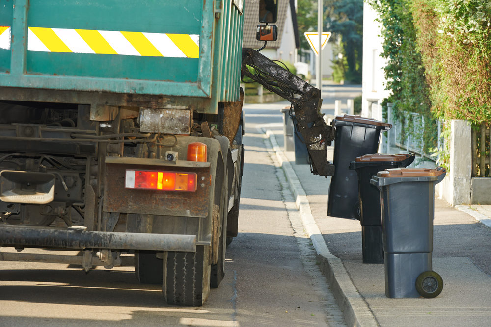 urban municipal recycling garbage collector truck loading waste and trash bin